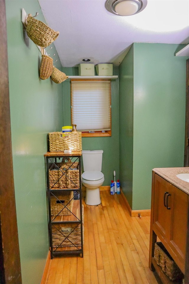 bathroom featuring toilet, hardwood / wood-style floors, and vanity