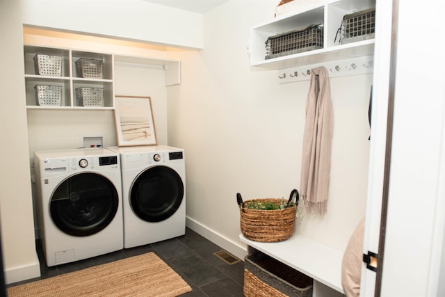 laundry area featuring separate washer and dryer and dark tile patterned floors