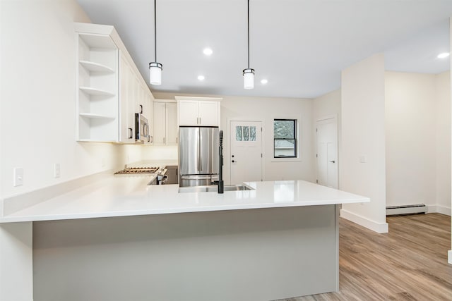 kitchen featuring a baseboard heating unit, kitchen peninsula, stainless steel appliances, decorative light fixtures, and white cabinets