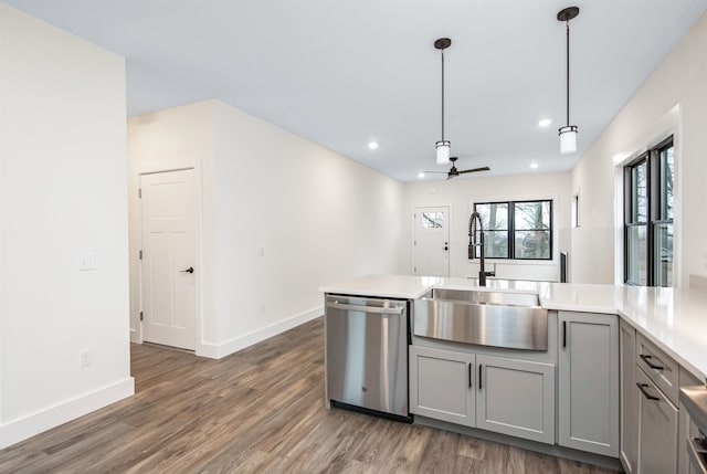 kitchen featuring dark hardwood / wood-style flooring, ceiling fan, stainless steel dishwasher, pendant lighting, and gray cabinets