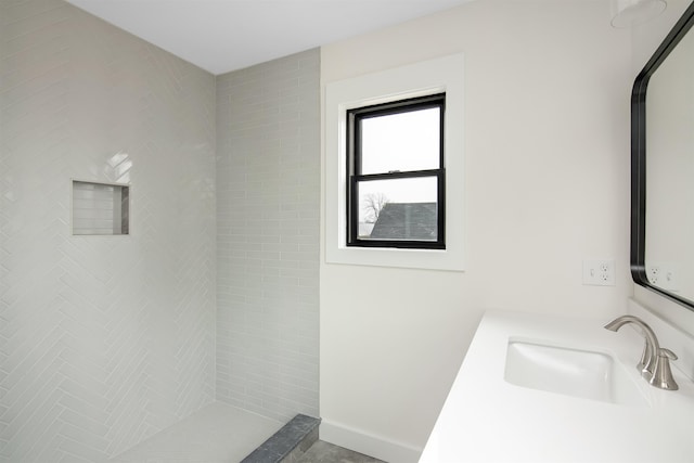 bathroom featuring vanity and tiled shower