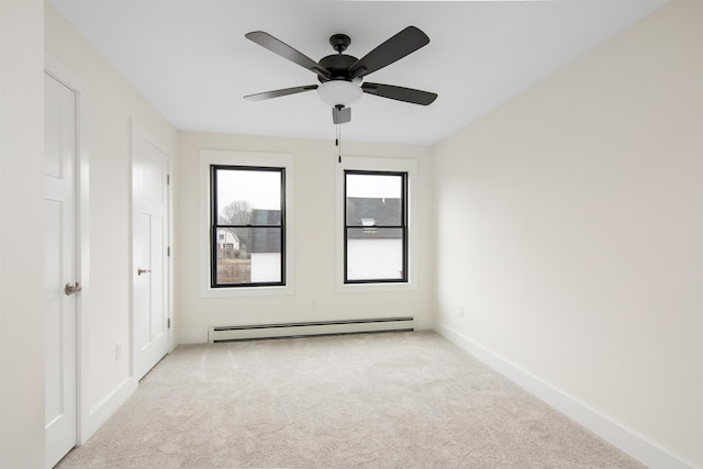 empty room with a baseboard heating unit, light colored carpet, and ceiling fan