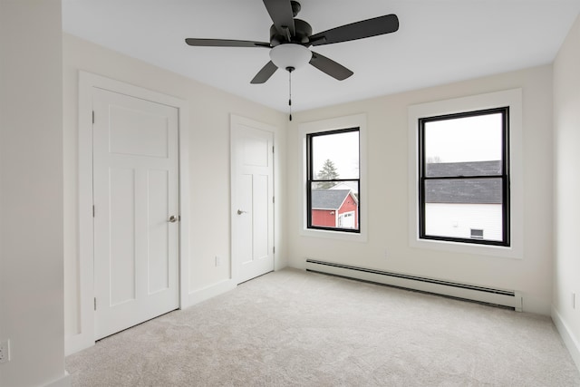 unfurnished bedroom with baseboard heating, light carpet, and ceiling fan