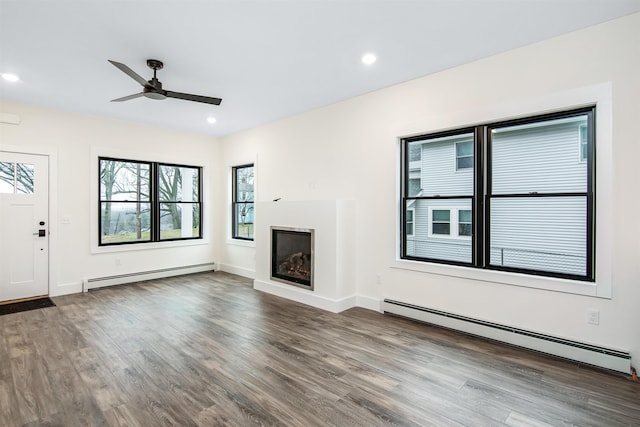 unfurnished living room with baseboard heating, wood-type flooring, and ceiling fan