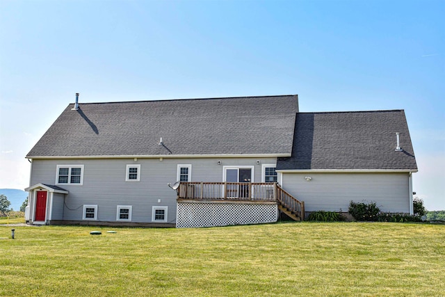 rear view of house featuring a deck and a lawn