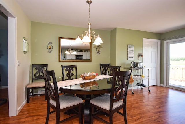 dining area with hardwood / wood-style flooring and a notable chandelier