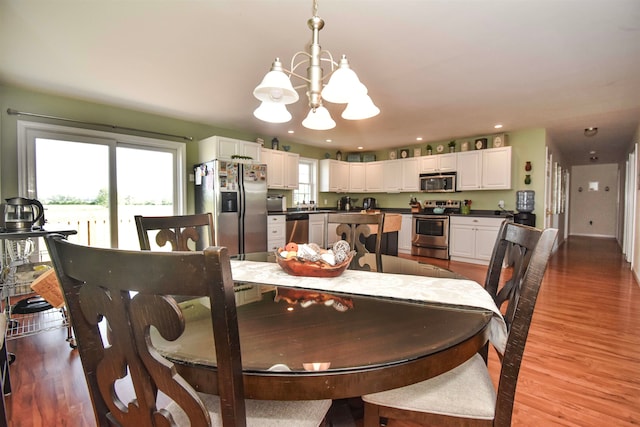 dining space with light hardwood / wood-style flooring and a notable chandelier