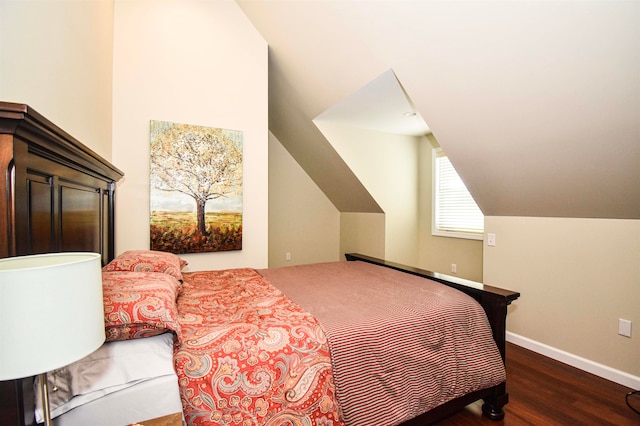 bedroom featuring dark wood-type flooring and vaulted ceiling