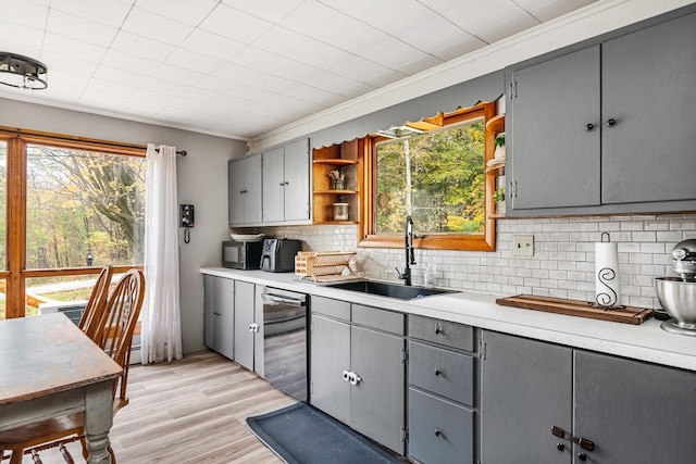 kitchen with ornamental molding, sink, and gray cabinetry