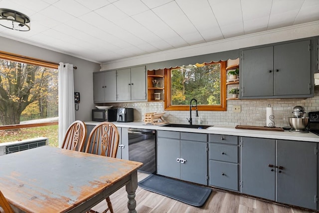 kitchen with backsplash, light hardwood / wood-style flooring, ornamental molding, black appliances, and sink