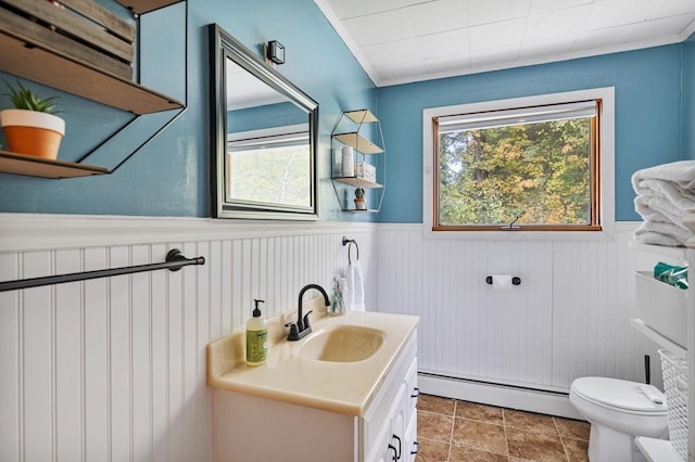 bathroom with baseboard heating, vanity, crown molding, and toilet