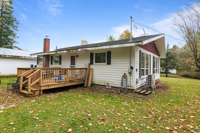 back of house featuring a wooden deck and a lawn