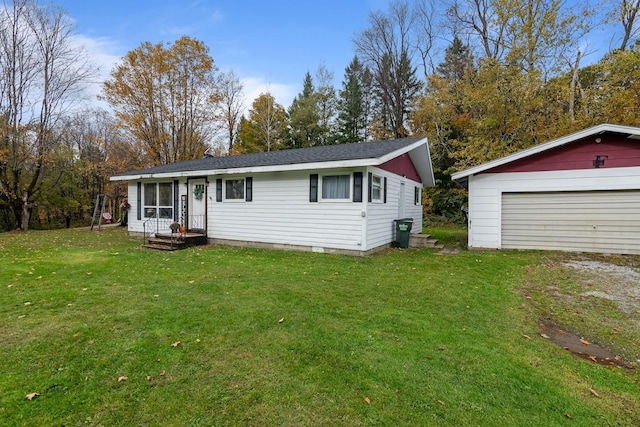 view of front facade with an outbuilding, a front lawn, and a garage