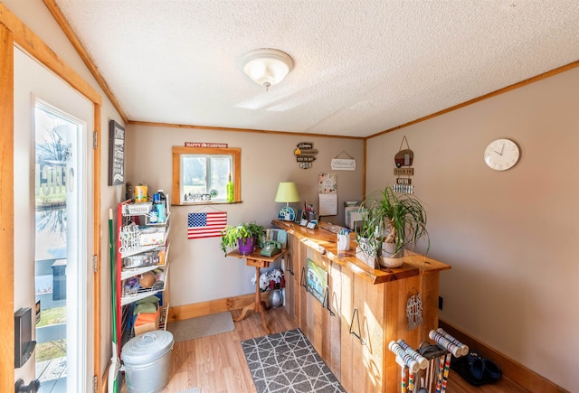 home office with hardwood / wood-style flooring, a healthy amount of sunlight, a textured ceiling, and ornamental molding