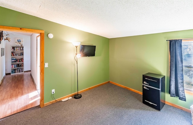 interior space with a textured ceiling and carpet flooring