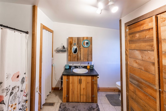 bathroom with vanity, toilet, and tile patterned floors