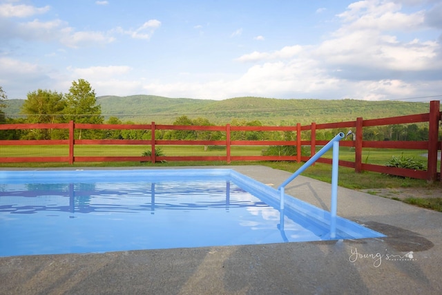 view of swimming pool featuring a mountain view and a rural view