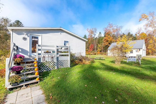 rear view of property featuring a wooden deck and a yard