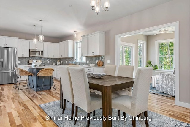 dining space featuring light hardwood / wood-style floors and a notable chandelier