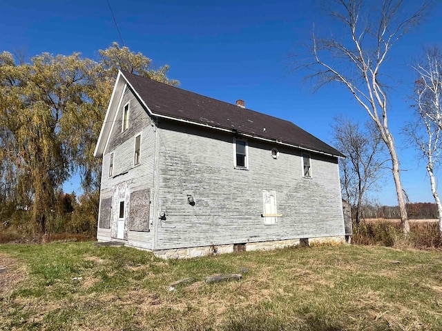 view of side of home with a lawn