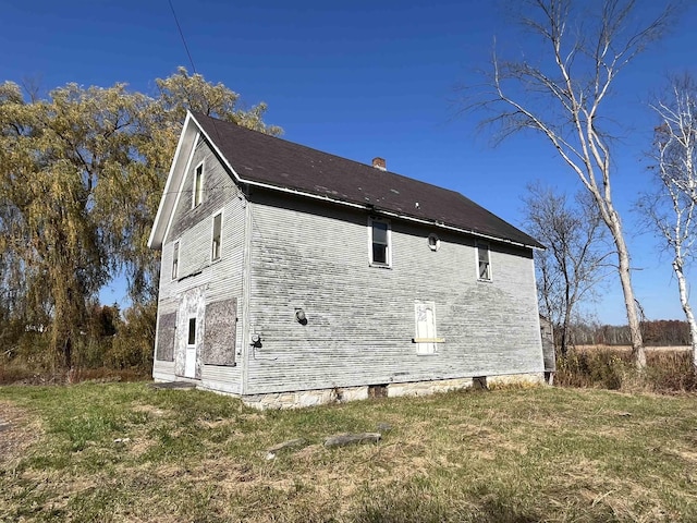 view of property exterior with a chimney and a yard