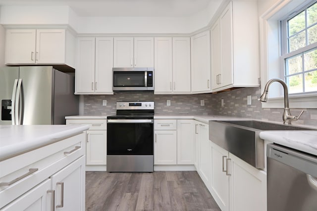 kitchen featuring light hardwood / wood-style floors, white cabinetry, and stainless steel appliances