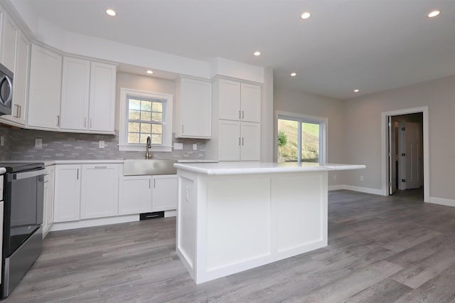 kitchen featuring white cabinets, sink, a wealth of natural light, and a kitchen island