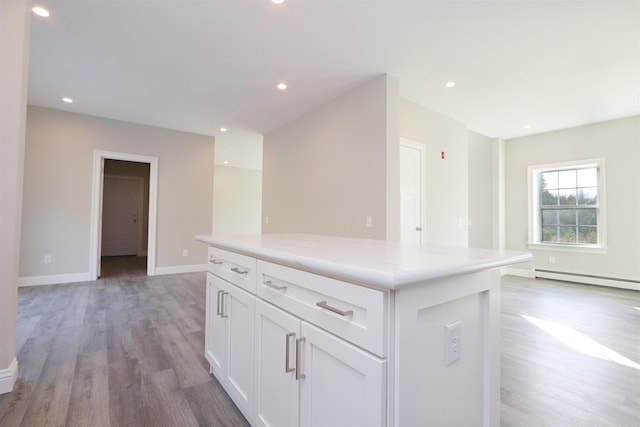 158 Deer Creek Ln, Saint Johnsbury, VT 05819 - kitchen with a kitchen island, baseboards, baseboard heating, light wood-type flooring, and white cabinets