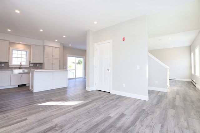 kitchen featuring sink, a center island, light wood-type flooring, and plenty of natural light