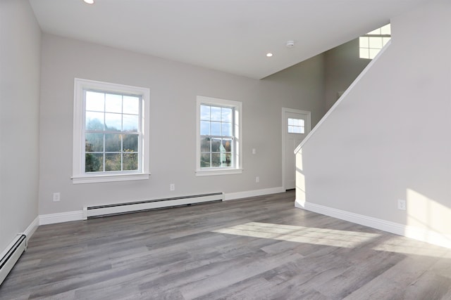 unfurnished living room with hardwood / wood-style floors and baseboard heating