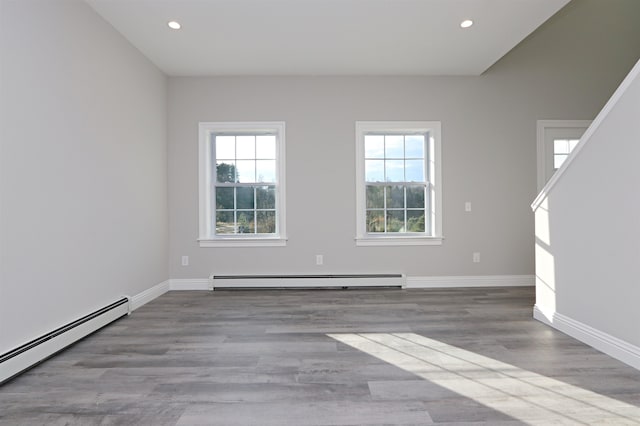 spare room with a baseboard radiator and light wood-type flooring