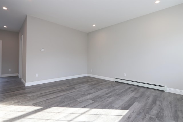 empty room with a baseboard radiator and light hardwood / wood-style floors