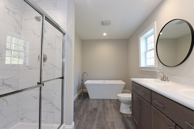 full bathroom with vanity, hardwood / wood-style floors, shower with separate bathtub, and toilet