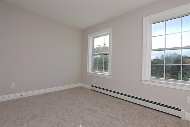 unfurnished room featuring baseboard heating, light carpet, and a wealth of natural light