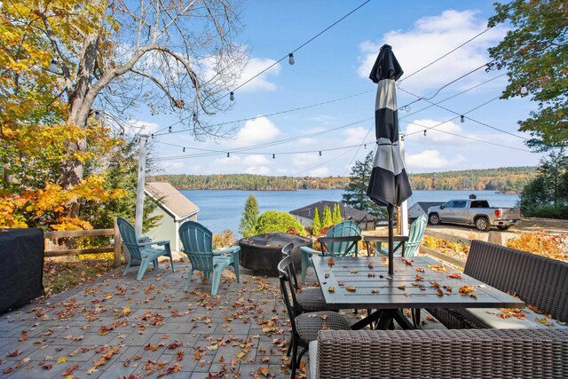 view of patio with a water view and a fire pit