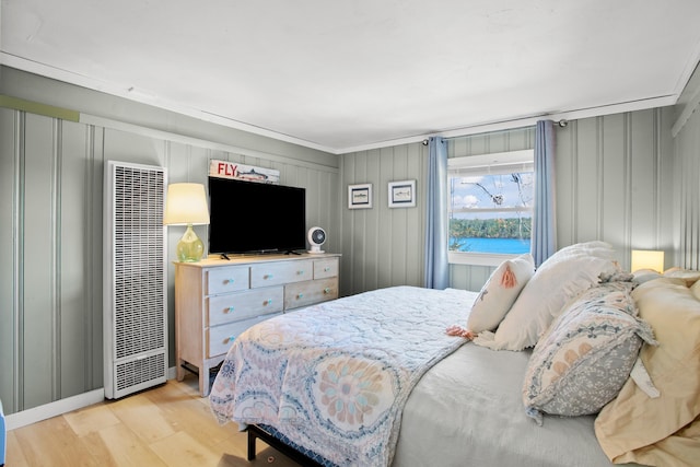 bedroom featuring ornamental molding and light hardwood / wood-style flooring