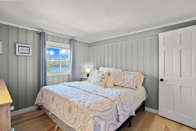 bedroom featuring a water view and light hardwood / wood-style floors