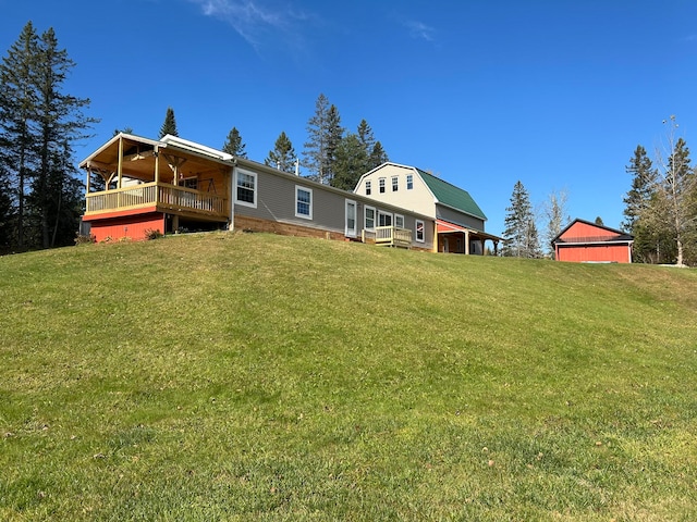 rear view of property featuring a yard and an outdoor structure