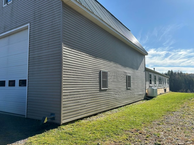 view of side of property featuring a lawn and a garage