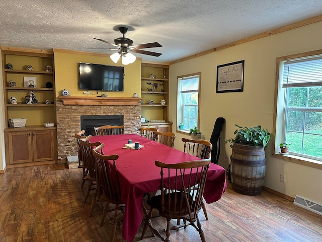 dining area with a textured ceiling, hardwood / wood-style flooring, and plenty of natural light