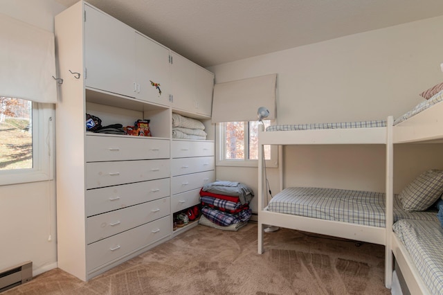 bedroom with a baseboard radiator and light colored carpet