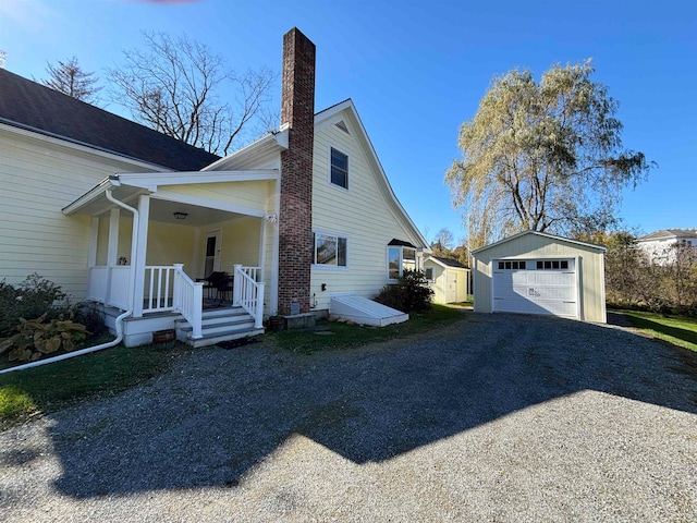 view of side of property with an outbuilding, a garage, and covered porch