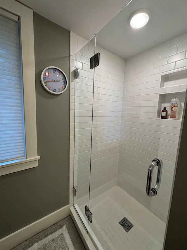 bathroom featuring a shower with shower door