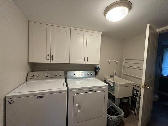 laundry area featuring cabinets, sink, and washer and clothes dryer