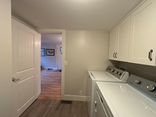 laundry room with washer and dryer, cabinets, and dark hardwood / wood-style floors