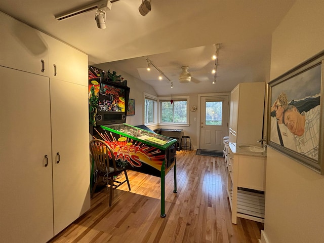 rec room featuring light hardwood / wood-style floors, ceiling fan, track lighting, and vaulted ceiling