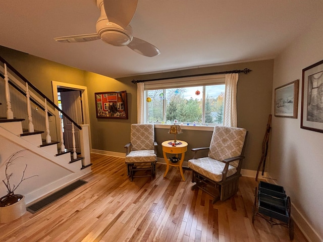 living area featuring light wood-type flooring and ceiling fan