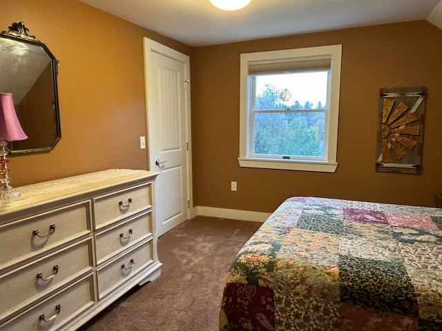 bedroom with lofted ceiling and dark colored carpet