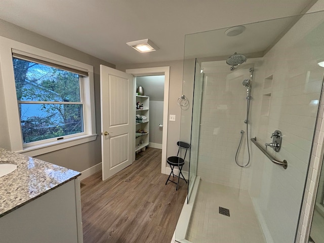 bathroom featuring vanity, tiled shower, and hardwood / wood-style flooring