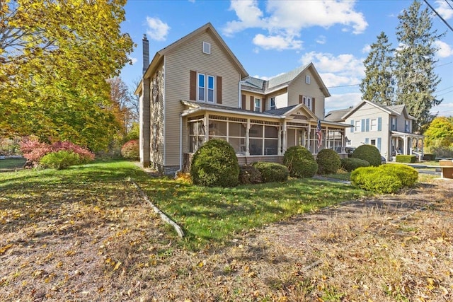 view of front facade with a front lawn and a sunroom